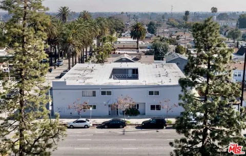 an aerial view of a house with a yard and parking spaces