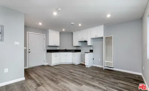 a kitchen with a refrigerator and white cabinets
