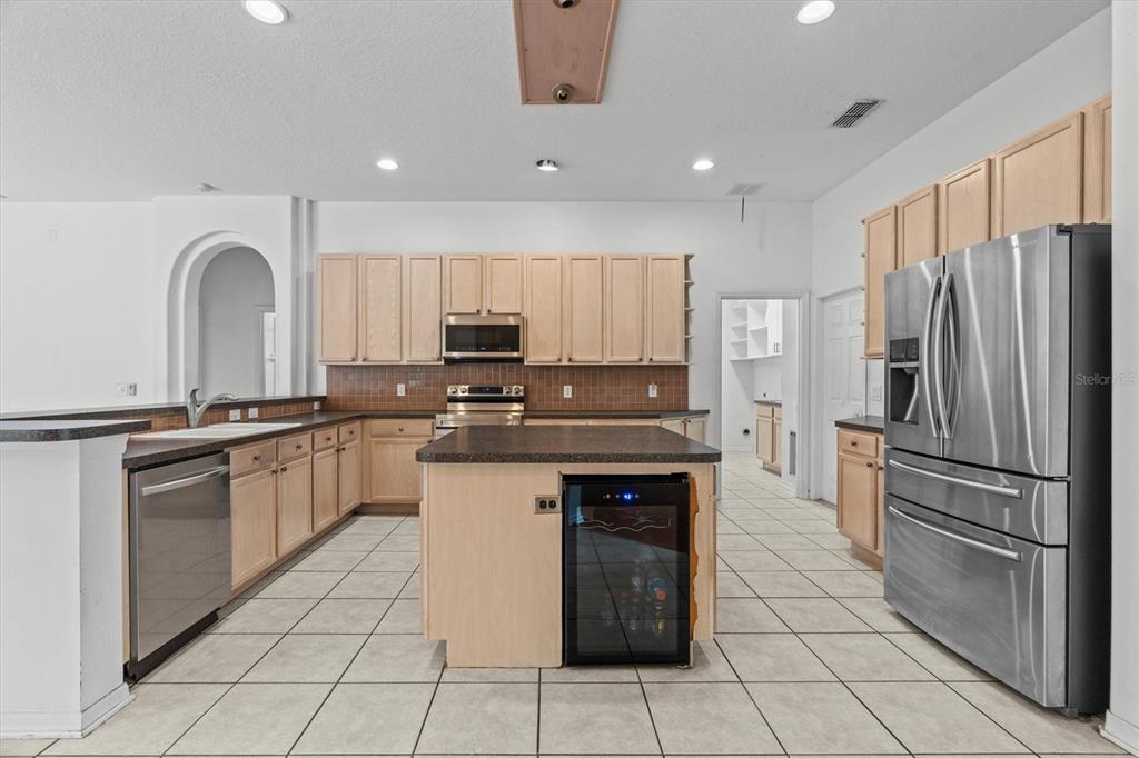 20744 Sheldon Street Orlando, FL 32833 - Photo 9 of 50 a kitchen with stainless steel appliances granite countertop a refrigerator and a stove top oven