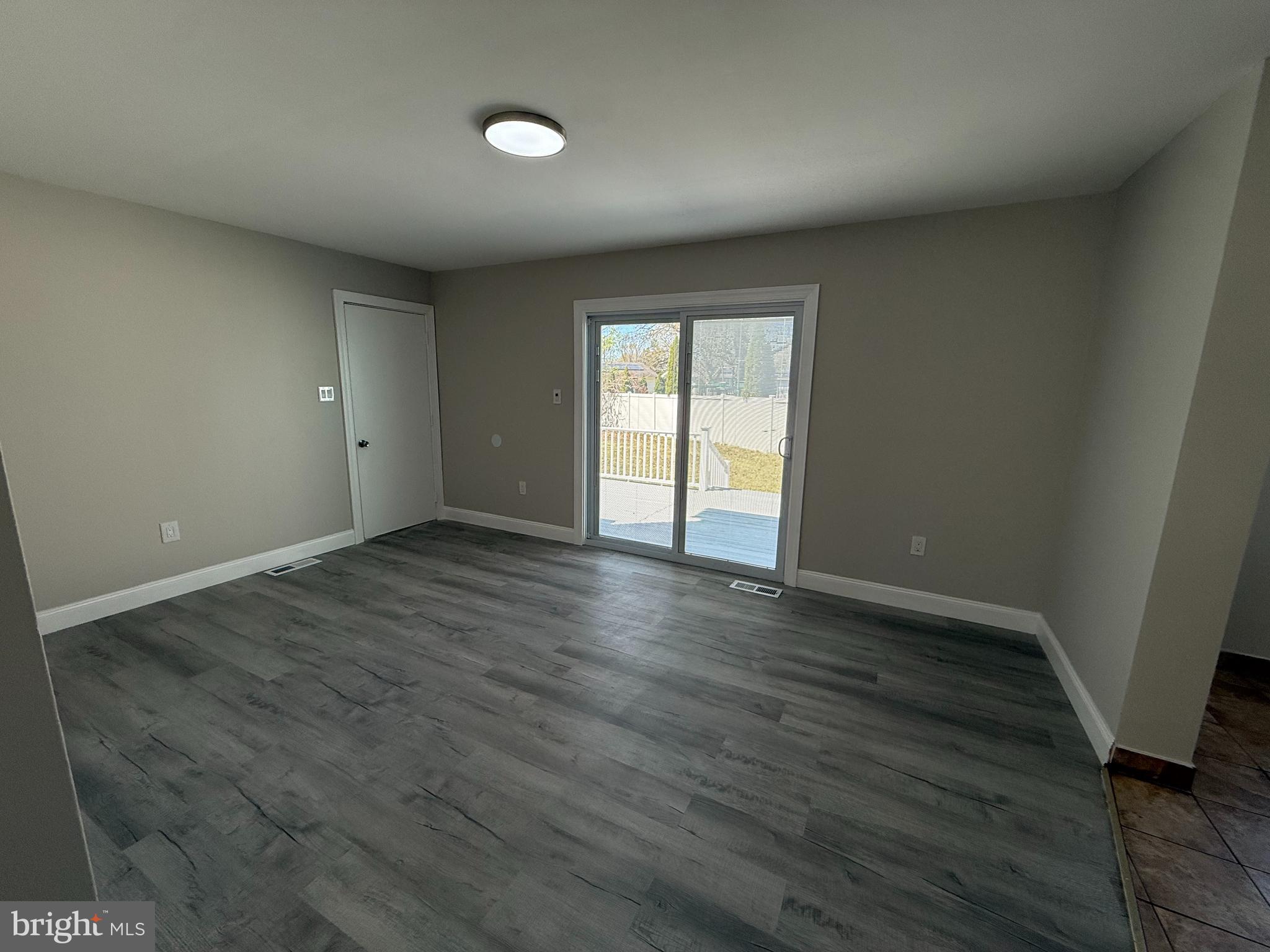 82 Dare Avenue Bridgeton, NJ 08302 - Photo 13 of 39 an empty room with wooden floor and windows