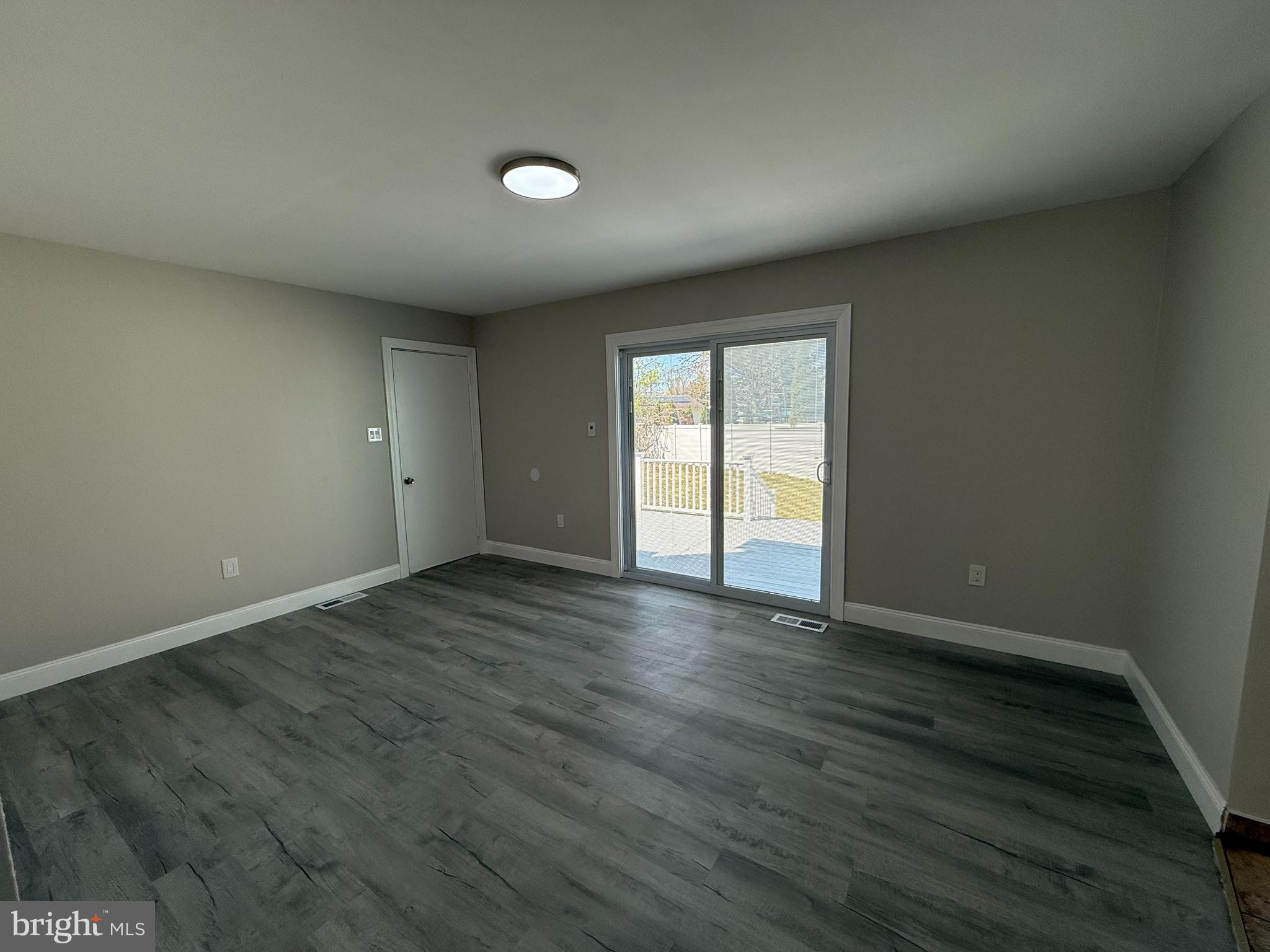 82 Dare Avenue Bridgeton, NJ 08302 - Photo 15 of 39 an empty room with wooden floor and windows