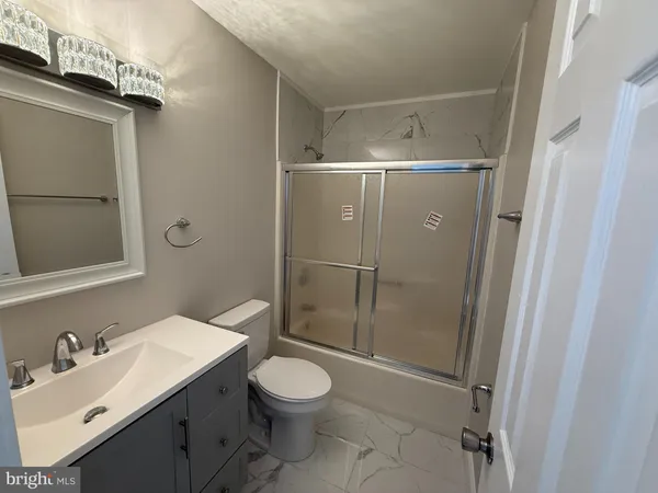 a bathroom with a sink mirror vanity and toilet
