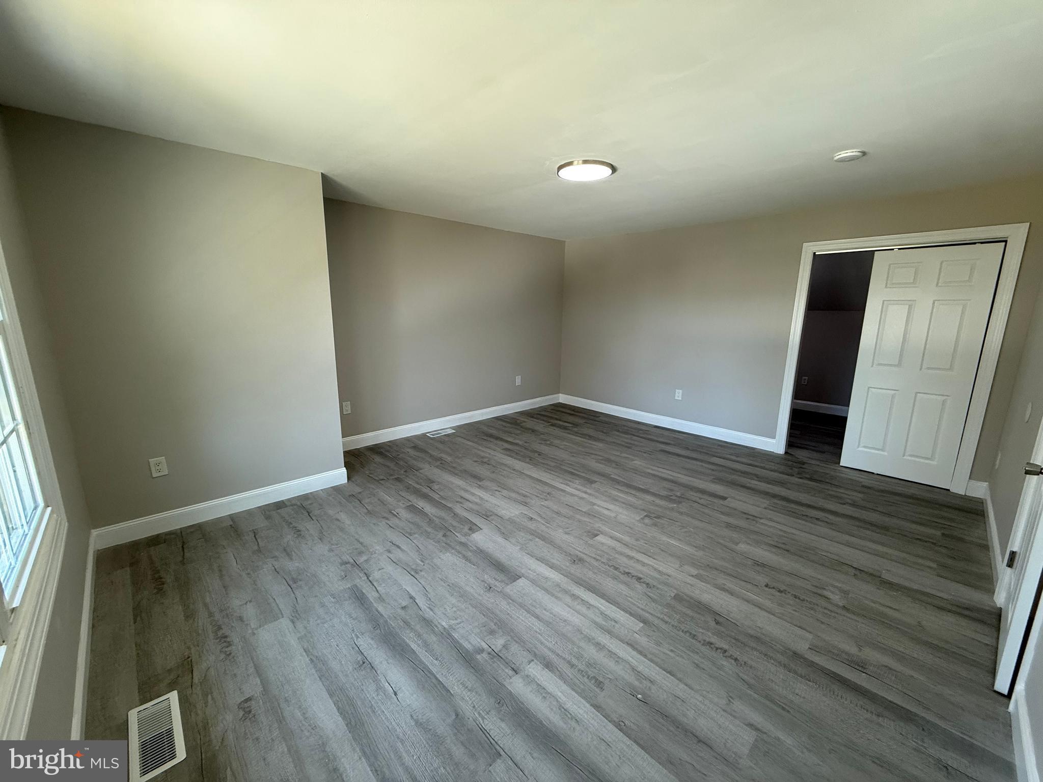 82 Dare Avenue Bridgeton, NJ 08302 - Photo 25 of 39 an empty room with wooden floor and windows