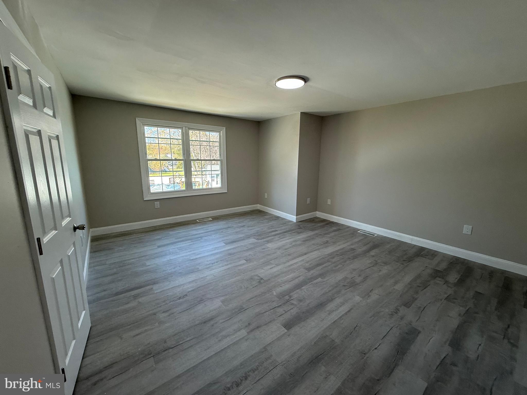 82 Dare Avenue Bridgeton, NJ 08302 - Photo 26 of 39 an empty room with wooden floor and a window