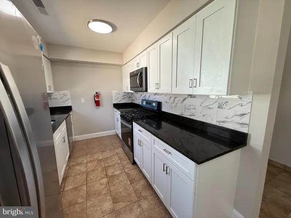 a kitchen with granite countertop a sink and a stove top oven