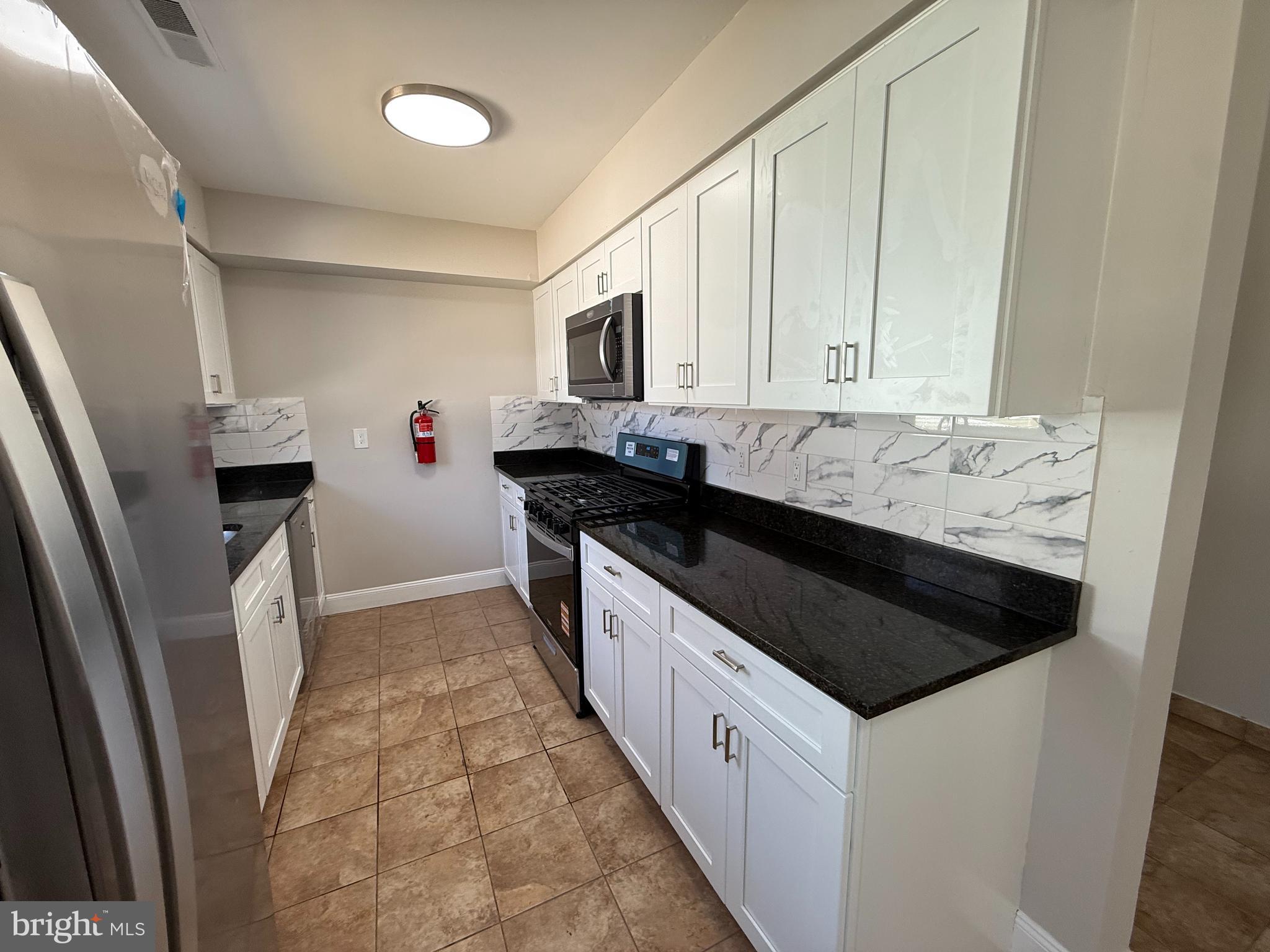 82 Dare Avenue Bridgeton, NJ 08302 - Photo 6 of 39 a kitchen with granite countertop a sink and a stove top oven