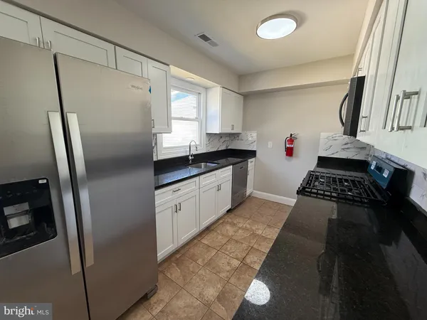a kitchen with stainless steel appliances granite countertop a refrigerator and a stove