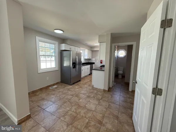 a view of a refrigerator in kitchen and a window