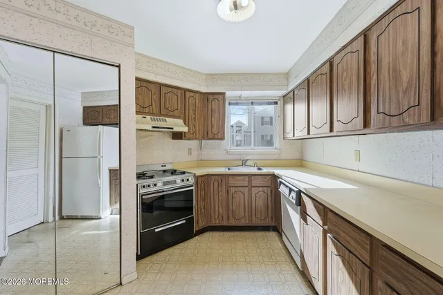 a kitchen with stainless steel appliances granite countertop a stove a sink and a refrigerator