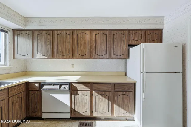 a kitchen with cabinets and a refrigerator
