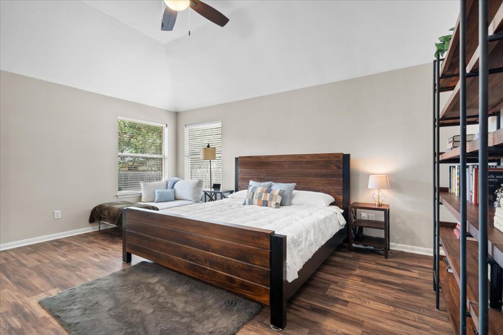13200 Calf Roping Trail Austin, TX 78727 - Photo 18 of 28 High vaulted ceilings and wood-look flooring enhance this light-filled bedroom design.