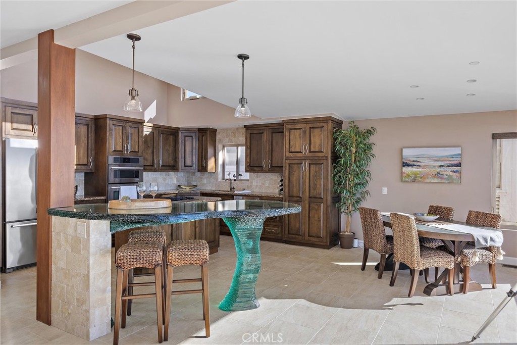 3352 Studio Drive Cayucos, CA 93430 - Photo 14 of 55 a kitchen with kitchen island a dining table chairs stainless steel appliances and cabinets
