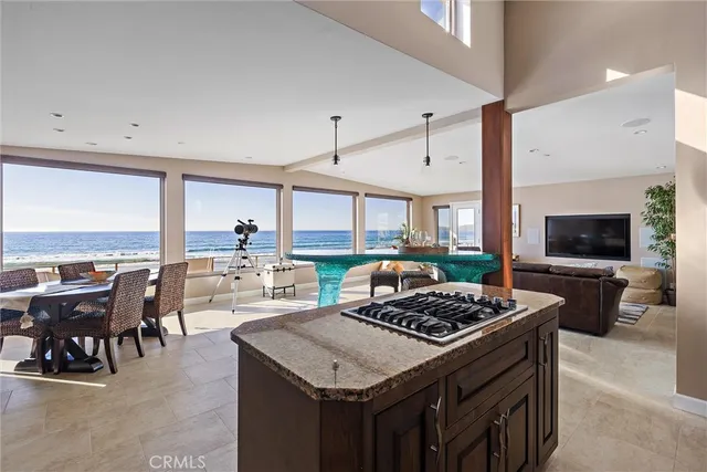 a kitchen with a stove a kitchen island a table and chairs in it