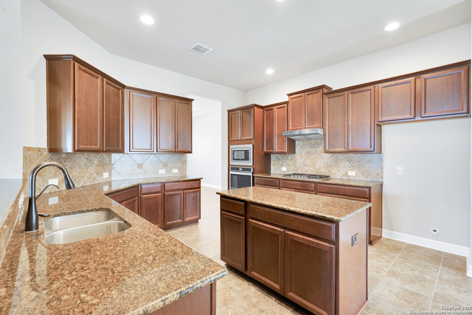 11923 Hollering Pass Schertz, TX 78154 - Photo 12 of 43 a kitchen with stainless steel appliances granite countertop a sink stove and refrigerator