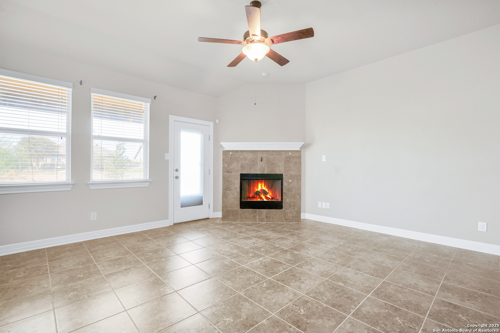 11923 Hollering Pass Schertz, TX 78154 - Photo 20 of 43 a view of an empty room with chandelier fan and fire place