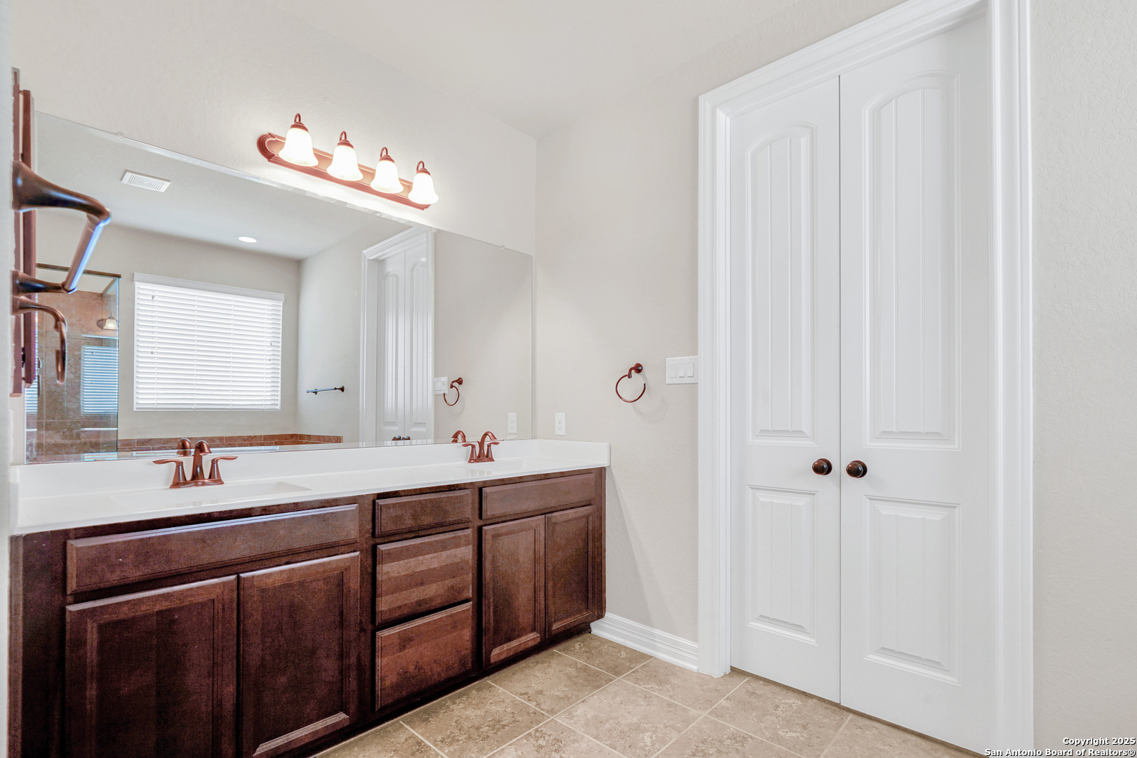 11923 Hollering Pass Schertz, TX 78154 - Photo 26 of 43 a bathroom with a double vanity sink a large mirror and a bathtub