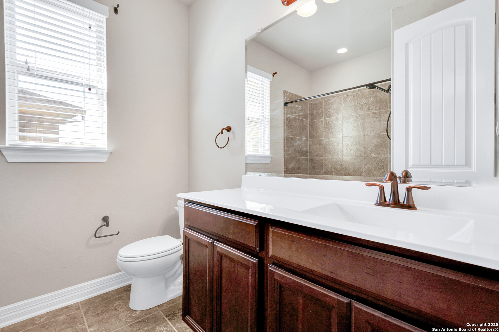 11923 Hollering Pass Schertz, TX 78154 - Photo 34 of 43 a bathroom with a granite countertop sink a toilet and a mirror