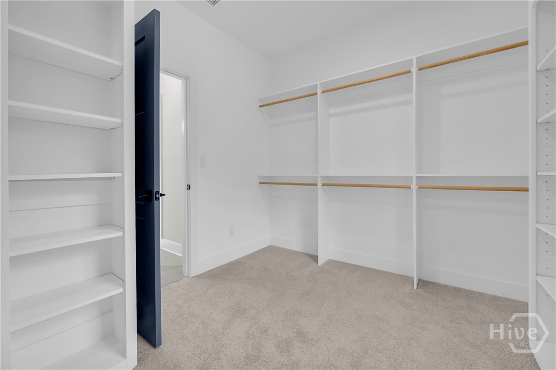 2476 St Martin Way Monroe, GA 30656 - Photo 51 of 75 Walk-in closet featuring built-in shelving, hanging rods, and carpet flooring