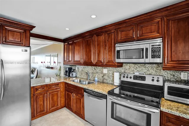 a kitchen with granite countertop stainless steel appliances and wooden cabinets