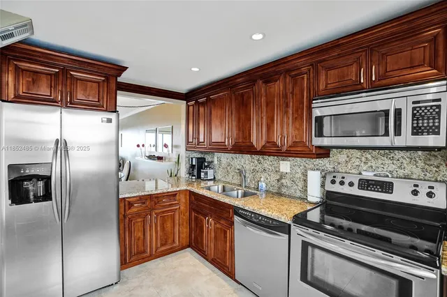 a kitchen with stainless steel appliances granite countertop a stove microwave and refrigerator