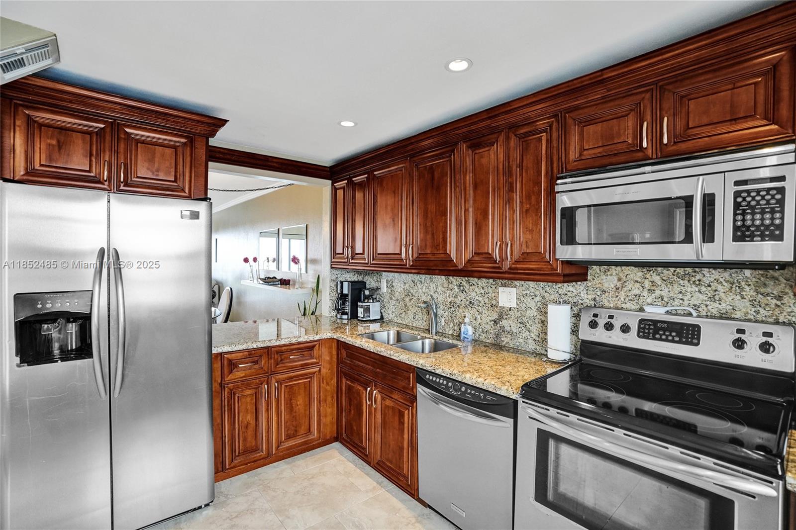 1401 North Riverside Drive, Unit 1005 Pompano Beach, FL 33062 - Photo 17 of 49 a kitchen with stainless steel appliances granite countertop a stove microwave and refrigerator