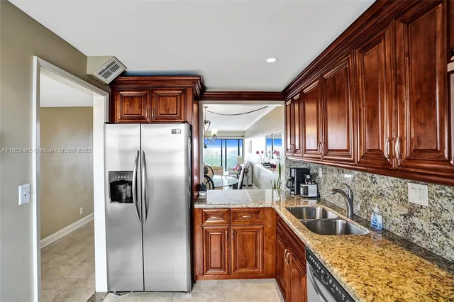 a kitchen with stainless steel appliances granite countertop a refrigerator a sink and dishwasher