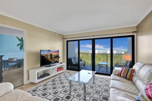 a living room with furniture a flat screen tv and a floor to ceiling window