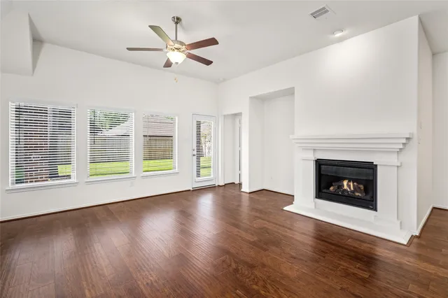 a view of wooden floor fire place refrigerator and window in a room