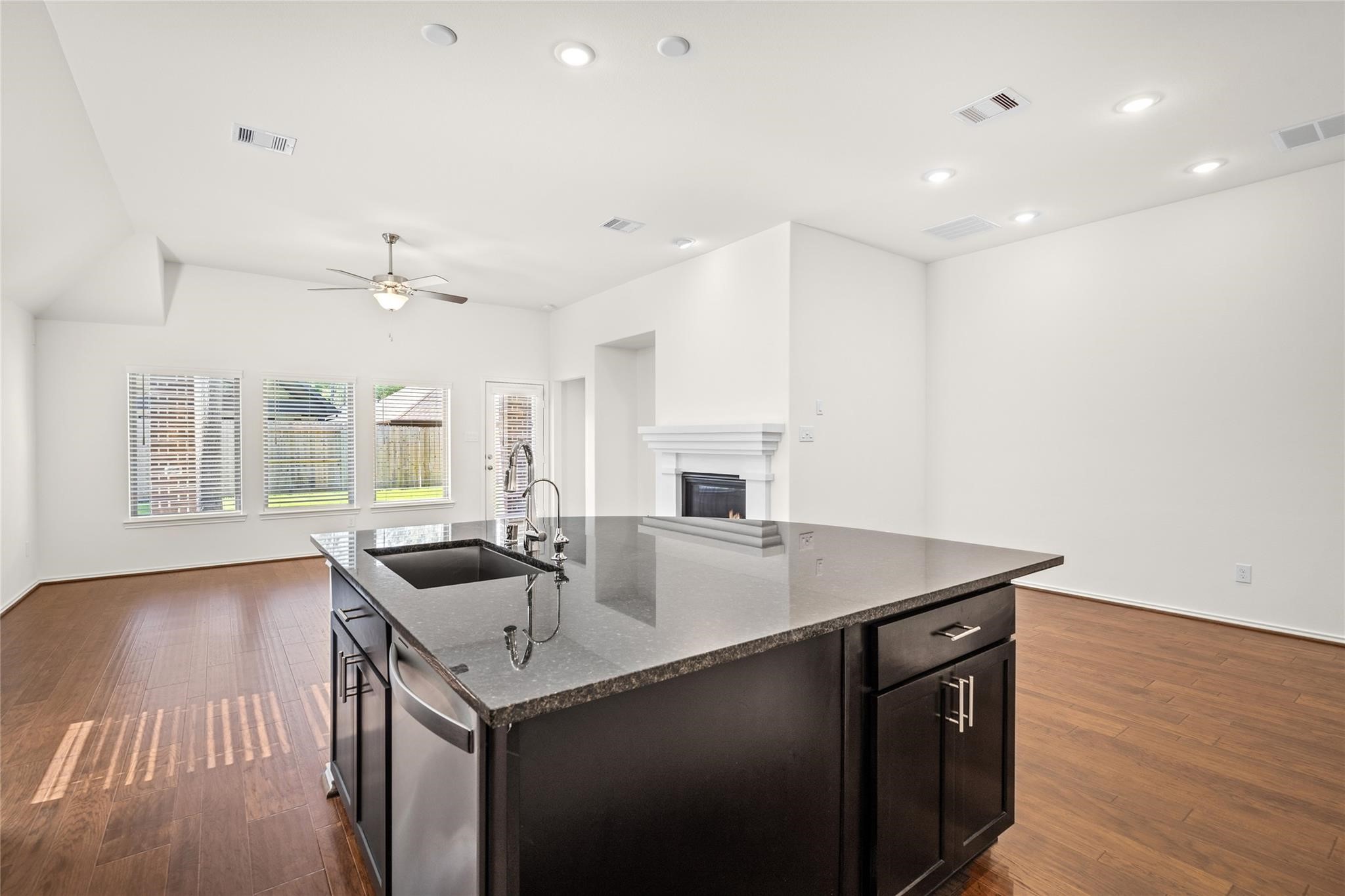 7480 Caprock Cyn Lane Porter, TX 77365 - Photo 4 of 13 a kitchen with a sink a stove and a microwave oven with wooden floor