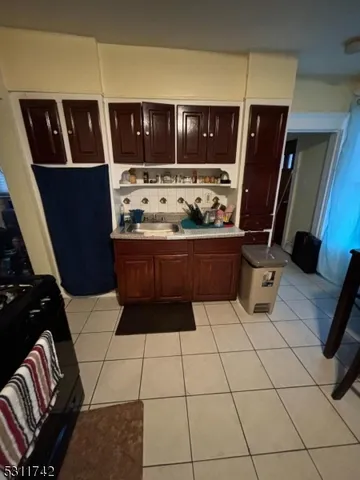 a living room with stainless steel appliances furniture and a refrigerator