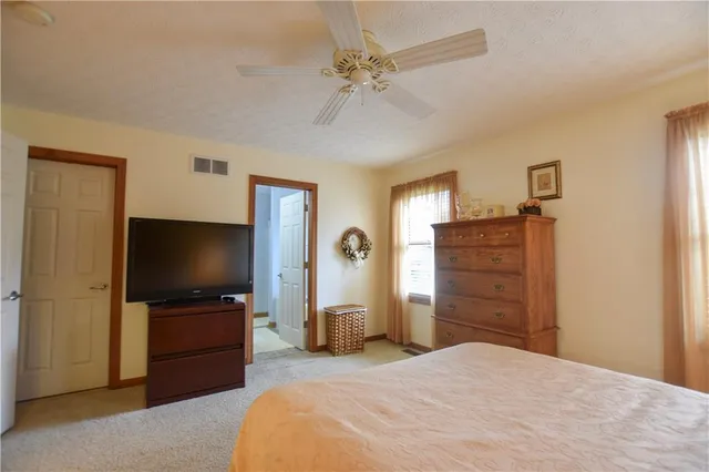 a bedroom with a bed and a flat tv screen on dresser
