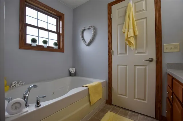 a bathroom with a tub sink and mirror