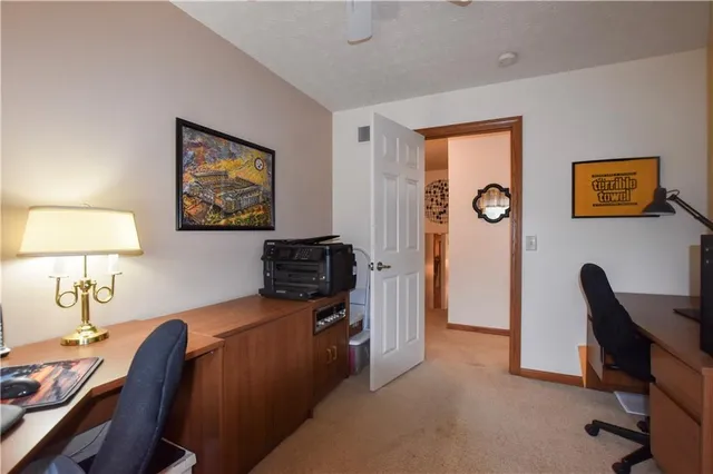 a view of a workspace with furniture and a window