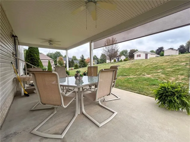 a view of a patio with a table chairs and garden