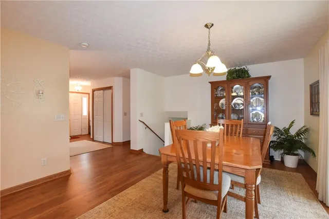 a dining room with furniture potted plants and wooden floor