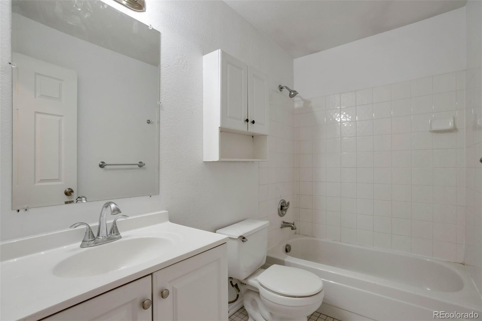 4437 Durham Court Denver, CO 80239 - Photo 9 of 15 a bathroom with a sink toilet vanity and shower