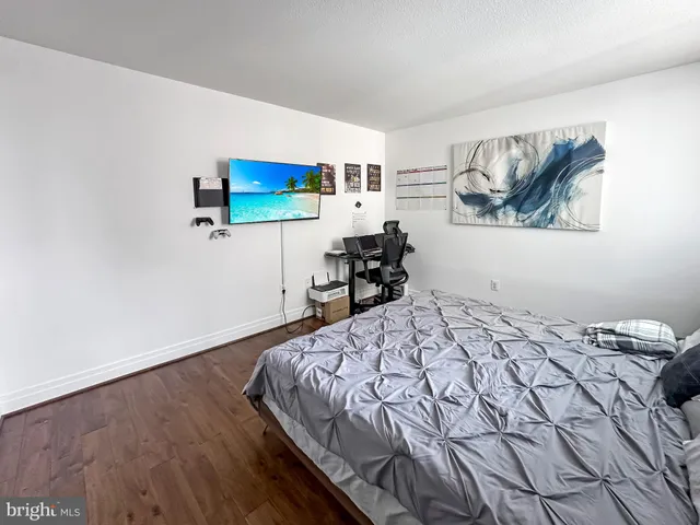 a bedroom with a bed and a wall painting