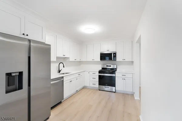 a kitchen with cabinets stainless steel appliances and a counter space