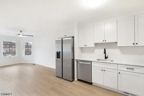 a kitchen with a refrigerator sink and cabinets