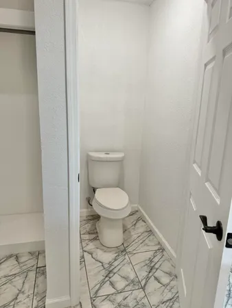 a bathroom with a toilet and a shower