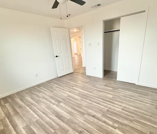 a view of an empty room with wooden floor