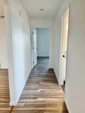 a view of a hallway with wooden floor and entryway