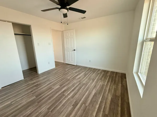 wooden floor in an empty room with a window