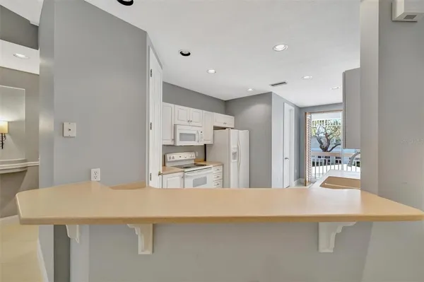 a kitchen with granite countertop white cabinets and white appliances