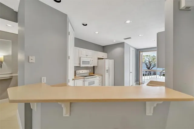 a kitchen with granite countertop white cabinets and white appliances