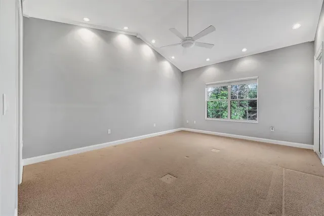 an empty room with windows and fan