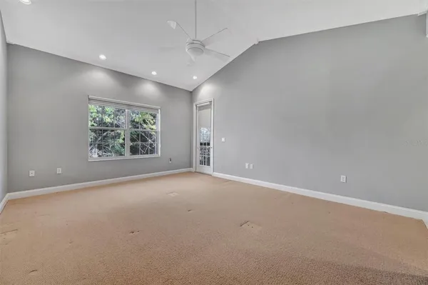 an empty room with windows and fan