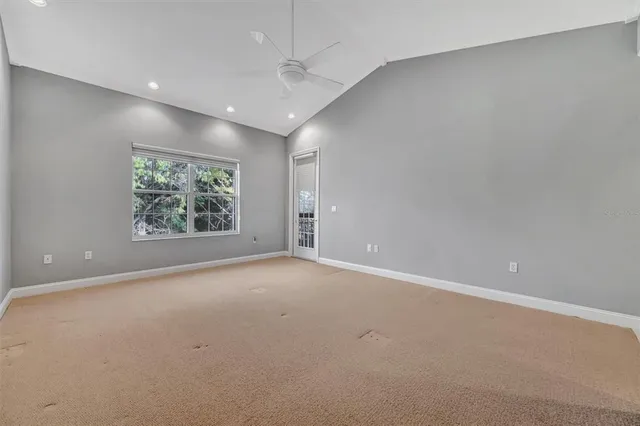 an empty room with windows and fan