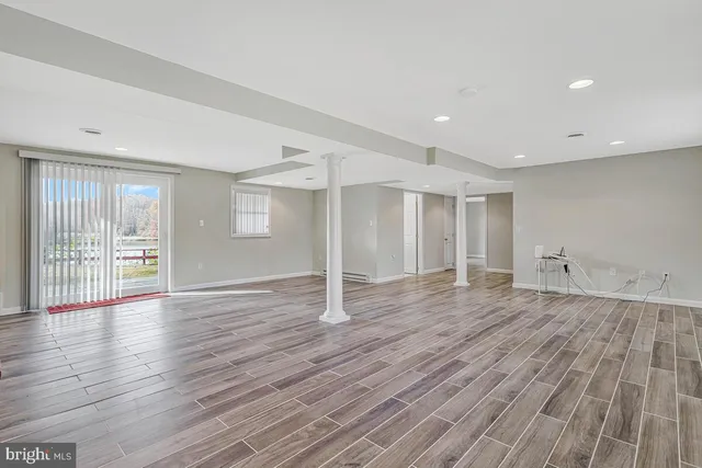 an empty room with wooden floor and glass door