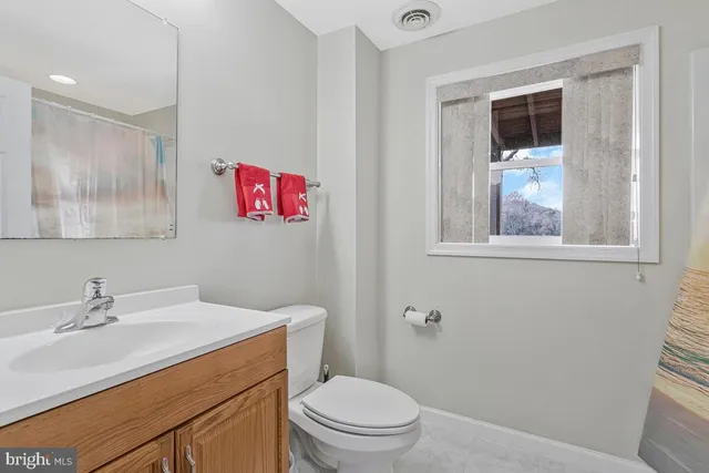a view of backyard with large tree and wooden fence